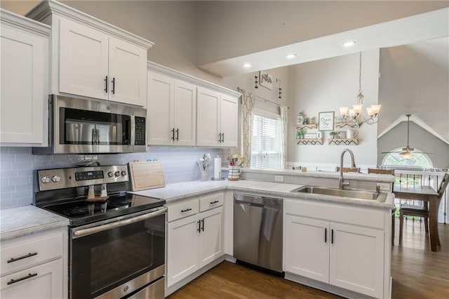 8103 NE 111th Ter, Kansas City, MO 64157 - kitchen featuring stainless steel appliances, a peninsula, a chandelier, white cabinetry, and light countertops