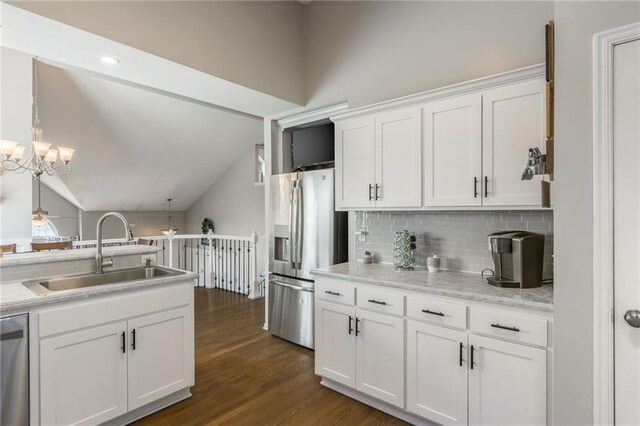 8103 NE 111th Ter, Kansas City, MO 64157 - kitchen featuring stainless steel appliances, white cabinets, backsplash, light countertops, and lofted ceiling