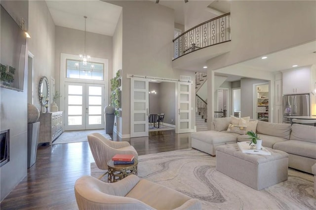 15716 Canterbury St, Overland Park, KS 66085 - living room with a towering ceiling, stairs, wood finished floors, a chandelier, and french doors