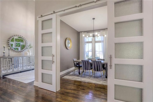 15716 Canterbury St, Overland Park, KS 66085 - dining area featuring wood finished floors, a chandelier, vaulted ceiling, and a barn door