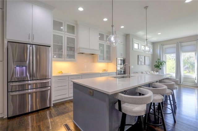 15716 Canterbury St, Overland Park, KS 66085 - kitchen with stainless steel appliances, dark wood finished floors, recessed lighting, an island with sink, and light countertops