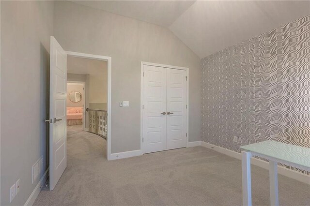 15716 Canterbury St, Overland Park, KS 66085 - unfurnished bedroom featuring light carpet, vaulted ceiling, and a closet