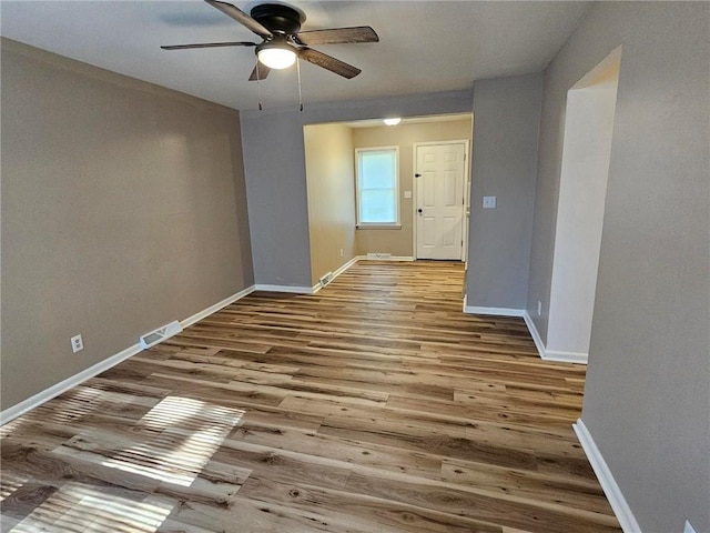 1615 N High St, Independence, MO 64050 - empty room with a ceiling fan and wood finished floors