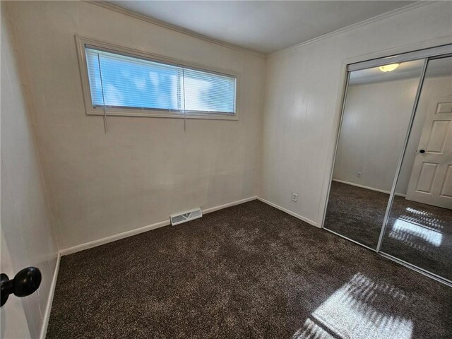 1615 N High St, Independence, MO 64050 - unfurnished bedroom with crown molding, carpet floors, and a closet