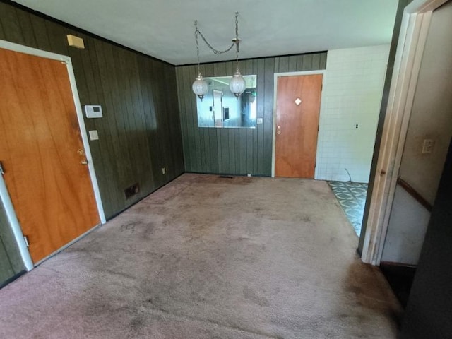 5001 E 41st St, Kansas City, MO 64130 - unfurnished dining area featuring carpet floors and wood walls