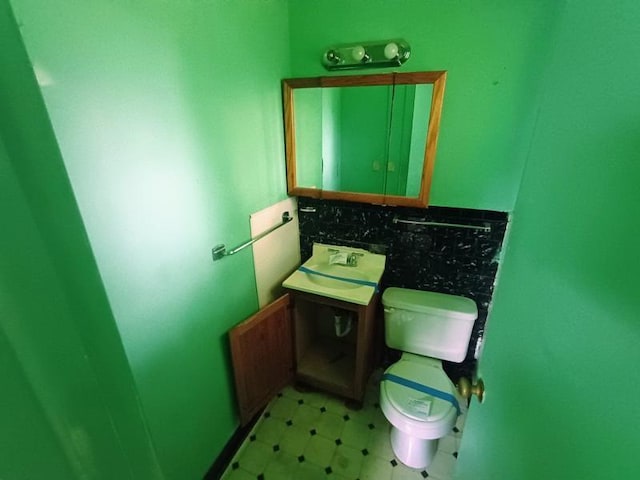 5001 E 41st St, Kansas City, MO 64130 - half bath with tile patterned floors, decorative backsplash, and vanity