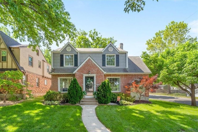 1295 W 71st Ter, Kansas City, MO 64114 - view of front facade with a front lawn, a chimney, and brick siding