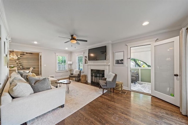 1295 W 71st Ter, Kansas City, MO 64114 - living area with dark wood-style floors, a fireplace with flush hearth, ceiling fan, recessed lighting, and ornamental molding