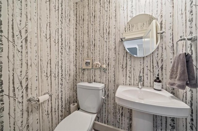 1295 W 71st Ter, Kansas City, MO 64114 - half bathroom featuring wallpapered walls and toilet