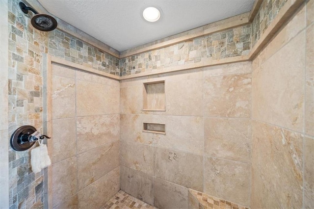 1295 W 71st Ter, Kansas City, MO 64114 - bathroom with a tile shower and a textured ceiling