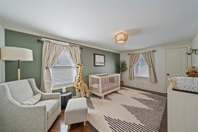 1295 W 71st Ter, Kansas City, MO 64114 - bedroom featuring crown molding, wood finished floors, and a nursery area