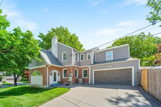 1295 W 71st Ter, Kansas City, MO 64114 - view of front of home with driveway, a garage, brick siding, and a chimney