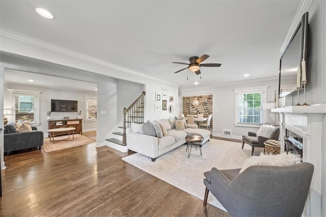 1295 W 71st Ter, Kansas City, MO 64114 - living area with stairs, a fireplace, a ceiling fan, ornamental molding, and wood finished floors