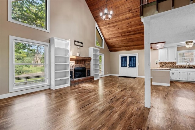 6727 Harvard Ave, Raytown, MO 64133 - unfurnished living room featuring high vaulted ceiling, dark wood-style floors, a fireplace, and wooden ceiling
