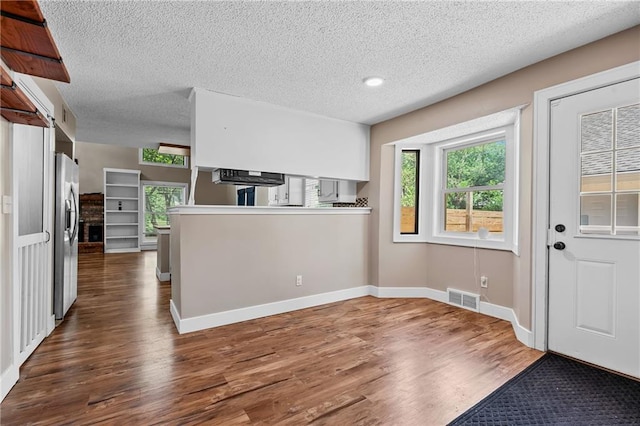 6727 Harvard Ave, Raytown, MO 64133 - kitchen with a textured ceiling, wood finished floors, plenty of natural light, and exhaust hood