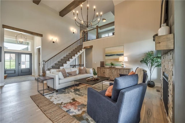 3705 W 187th St, Overland Park, KS 66085 - living area featuring a chandelier, a high ceiling, wood finished floors, stairs, and a fireplace