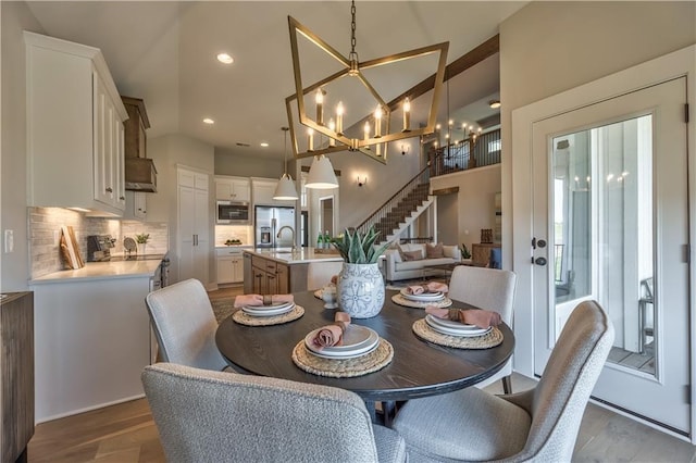 3705 W 187th St, Overland Park, KS 66085 - dining room with a chandelier, stairs, wood finished floors, recessed lighting, and lofted ceiling