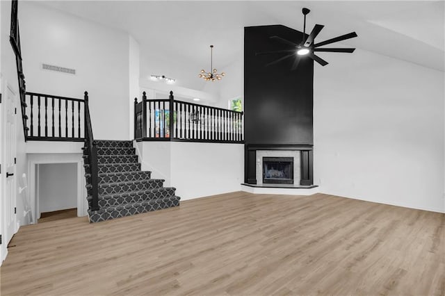 220 NE Dreamweaver Ave, Lees Summit, MO 64086 - unfurnished living room featuring high vaulted ceiling, a ceiling fan, wood finished floors, a chandelier, and stairs