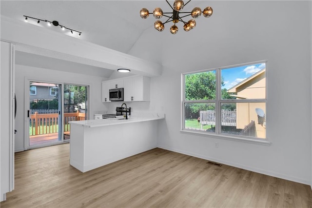 220 NE Dreamweaver Ave, Lees Summit, MO 64086 - kitchen featuring stainless steel microwave, range with electric cooktop, white cabinetry, light wood finished floors, and vaulted ceiling