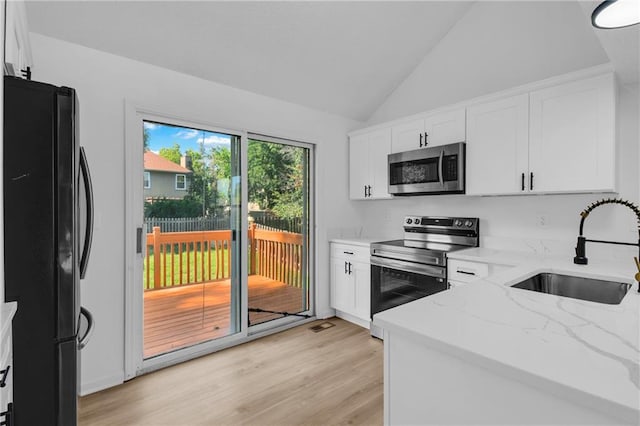 220 NE Dreamweaver Ave, Lees Summit, MO 64086 - kitchen with stainless steel appliances, light stone countertops, white cabinets, light wood-style flooring, and lofted ceiling