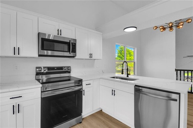 220 NE Dreamweaver Ave, Lees Summit, MO 64086 - kitchen featuring stainless steel appliances, a peninsula, light wood-style floors, white cabinets, and light stone countertops