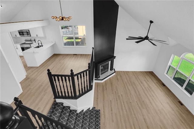 220 NE Dreamweaver Ave, Lees Summit, MO 64086 - living area featuring high vaulted ceiling, light wood-style floors, a chandelier, and stairs