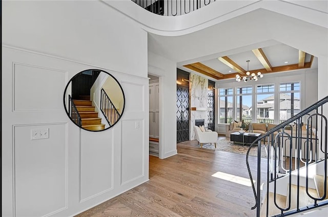 18501 Mohawk Ln, Overland Park, KS 66085 - entryway featuring stairs, a chandelier, coffered ceiling, light wood-type flooring, and beamed ceiling