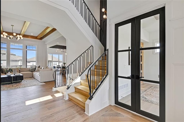 18501 Mohawk Ln, Overland Park, KS 66085 - foyer entrance featuring a chandelier, french doors, stairs, a towering ceiling, and beam ceiling