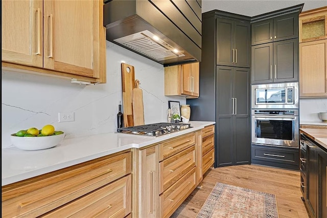 18501 Mohawk Ln, Overland Park, KS 66085 - kitchen with stainless steel appliances, range hood, light wood-style flooring, light countertops, and light brown cabinets