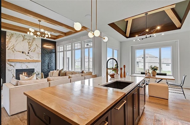 18501 Mohawk Ln, Overland Park, KS 66085 - kitchen with wooden counters, a chandelier, beam ceiling, open floor plan, and light wood-type flooring