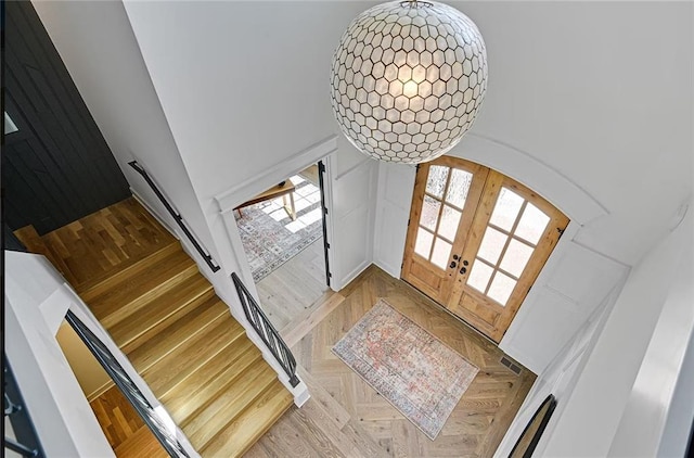 18501 Mohawk Ln, Overland Park, KS 66085 - foyer entrance with french doors, a high ceiling, and arched walkways