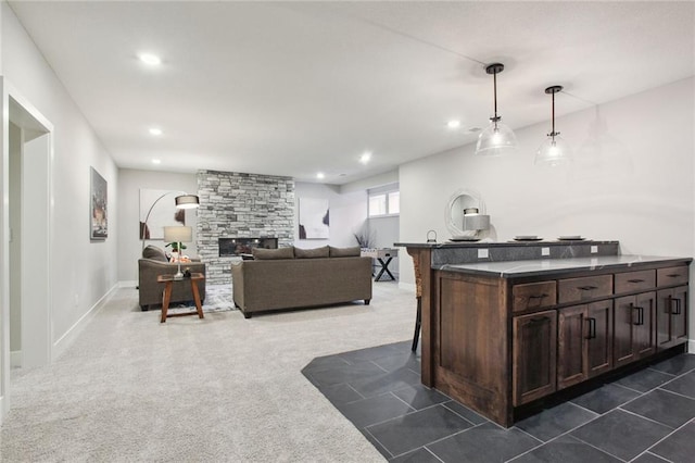 17162 S Heatherwood St, Olathe, KS 66062 - kitchen with dark countertops, dark brown cabinets, recessed lighting, a breakfast bar, and pendant lighting