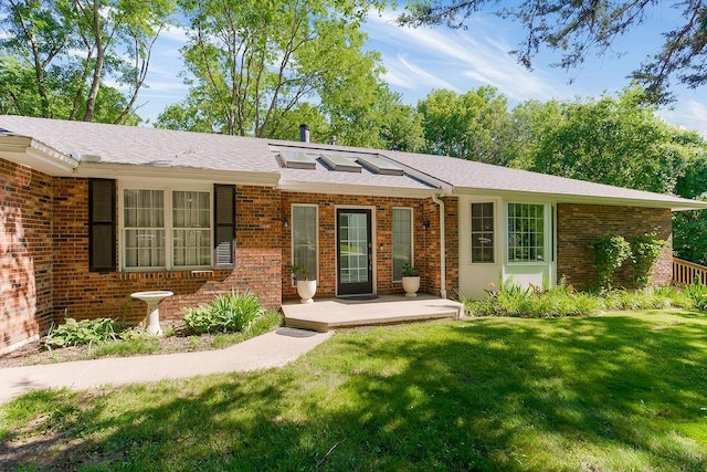 1100 Sycamore Ridge Dr, Lansing, KS 66043 - ranch-style home featuring brick siding, a front yard, and roof with shingles