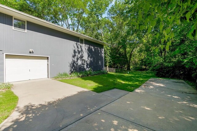 1100 Sycamore Ridge Dr, Lansing, KS 66043 - view of side of home featuring a yard, a garage, and concrete driveway