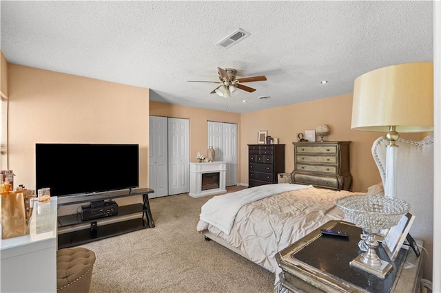 11102 Winchester Ave, Kansas City, MO 64134 - bedroom with multiple closets, carpet flooring, a textured ceiling, and a ceiling fan
