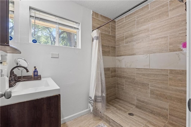 11102 Winchester Ave, Kansas City, MO 64134 - bathroom with tiled shower, vanity, and a textured ceiling