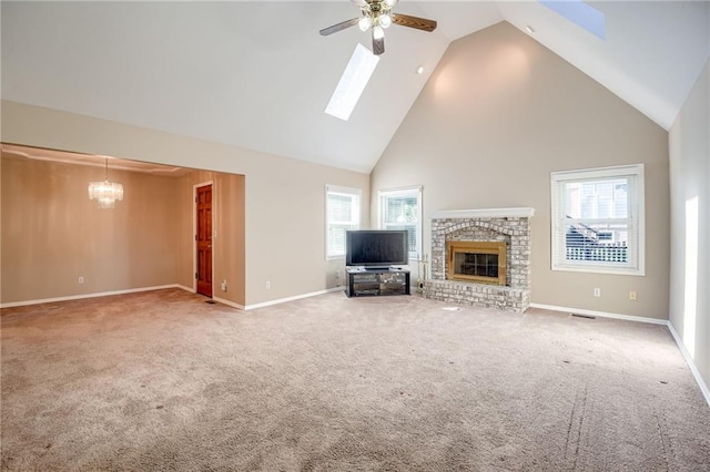 411 SW Windmill Ln, Lees Summit, MO 64082 - unfurnished living room with a ceiling fan, a skylight, high vaulted ceiling, a brick fireplace, and carpet flooring