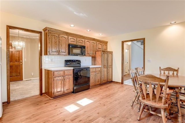 411 SW Windmill Ln, Lees Summit, MO 64082 - kitchen with black appliances, light wood-style flooring, light countertops, decorative backsplash, and recessed lighting
