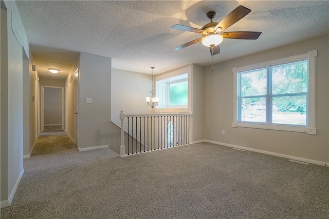 1613 SE Royal St, Oak Grove, MO 64075 - unfurnished room with healthy amount of natural light, a chandelier, a textured ceiling, carpet, and a ceiling fan