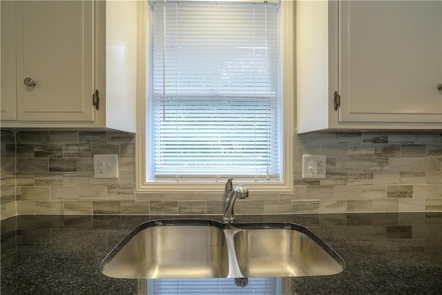 1613 SE Royal St, Oak Grove, MO 64075 - kitchen featuring dark stone counters, decorative backsplash, and white cabinetry