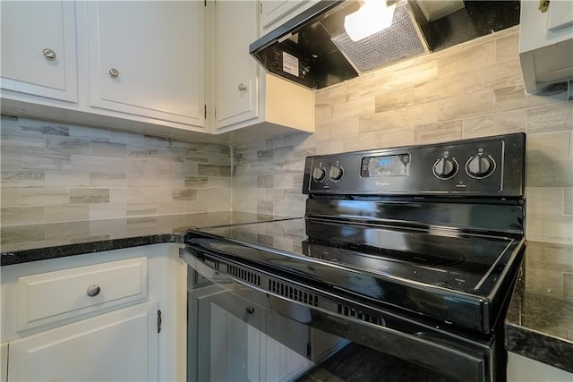 1613 SE Royal St, Oak Grove, MO 64075 - kitchen with black electric range, exhaust hood, tasteful backsplash, white cabinets, and dark stone counters