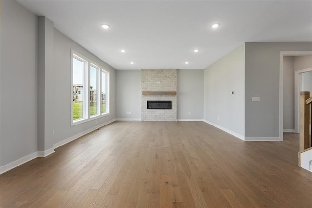 16778 S Twilight Ln, Olathe, KS 66062 - unfurnished living room featuring wood-type flooring, a fireplace, and recessed lighting