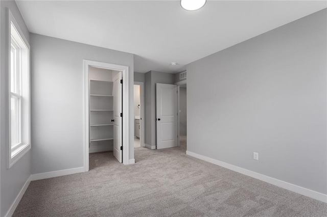 16778 S Twilight Ln, Olathe, KS 66062 - unfurnished bedroom with light carpet, a spacious closet, multiple windows, and a closet