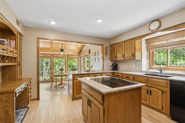 12117 Knox St, Overland Park, KS 66213 - kitchen featuring black appliances, brown cabinets, a peninsula, plenty of natural light, and recessed lighting