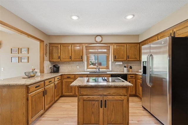 12117 Knox St, Overland Park, KS 66213 - kitchen with black appliances, a peninsula, brown cabinetry, light stone countertops, and recessed lighting