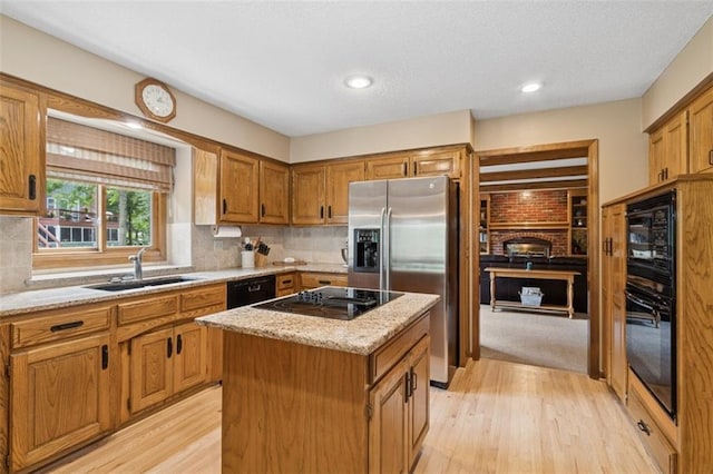 12117 Knox St, Overland Park, KS 66213 - kitchen featuring black appliances, light wood finished floors, a kitchen island, brown cabinets, and tasteful backsplash
