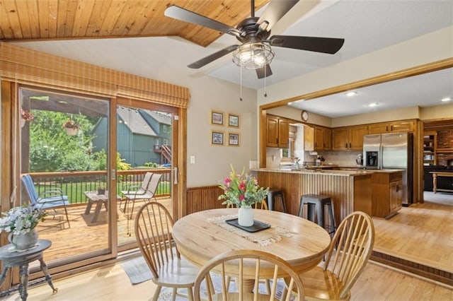 12117 Knox St, Overland Park, KS 66213 - dining space with a wainscoted wall, light wood finished floors, vaulted ceiling, ceiling fan, and wooden walls