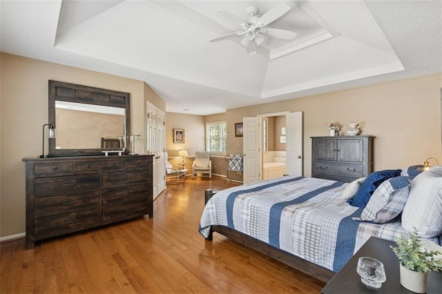 12117 Knox St, Overland Park, KS 66213 - bedroom with a tray ceiling, wood finished floors, ensuite bath, and a ceiling fan