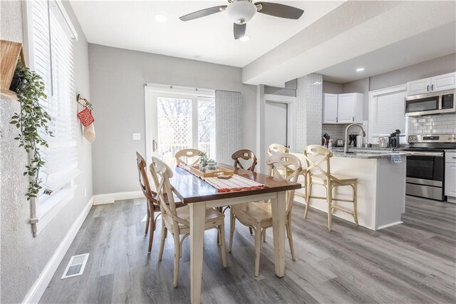 3221 E 11th St, Kansas City, MO 64127 - dining space featuring light wood-type flooring, ceiling fan, and recessed lighting