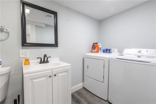 3221 E 11th St, Kansas City, MO 64127 - washroom featuring washing machine and clothes dryer, wood finished floors, and cabinet space